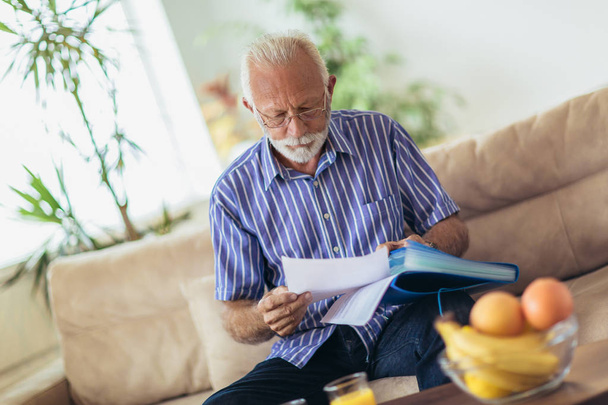 Hombre mayor revisando las finanzas del hogar
. - Foto, Imagen