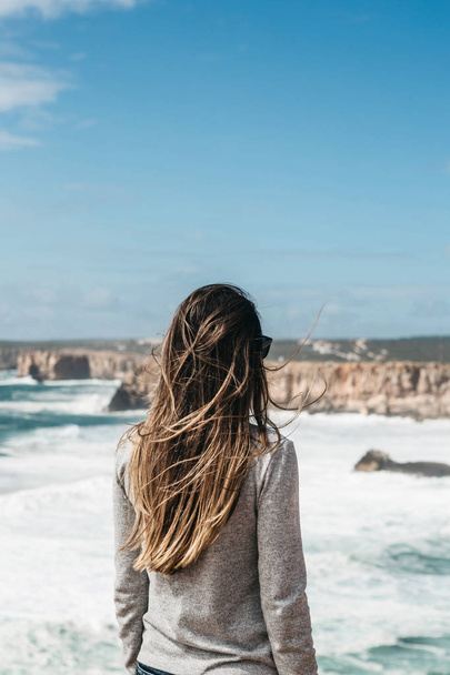 Dziewczyna w samotności podziwia piękny widok na Ocean Atlantycki. - Zdjęcie, obraz