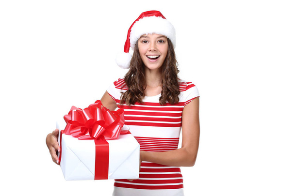 Beautiful girl in santa hat with gift box on white background - Фото, изображение