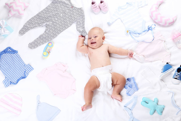 Baby boy with fashion clothes lying on white bed - Foto, immagini