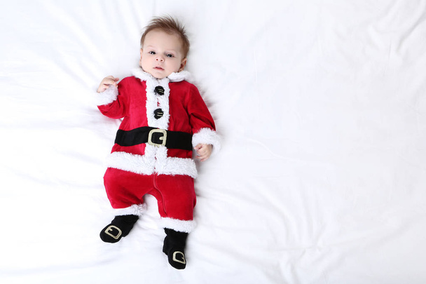 Little boy in christmas costume lying on bed - Valokuva, kuva