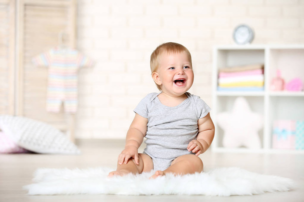 Happy baby boy sitting on carpet at home - Foto, Imagen