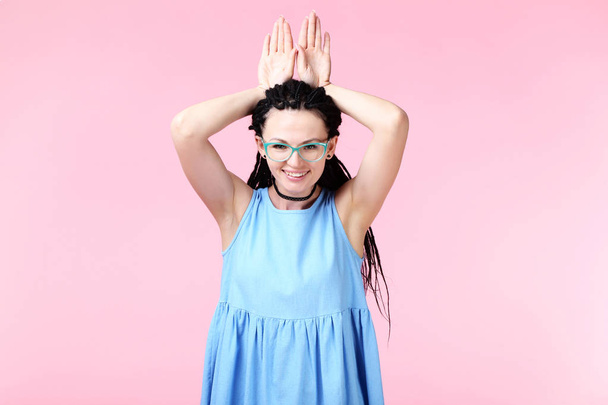 Young woman in blue dress on pink background - Foto, Imagen