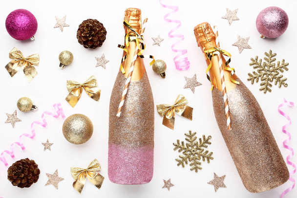 Шампанські пляшки з різдвяними прикрасами на білому тлі
 - Фото, зображення