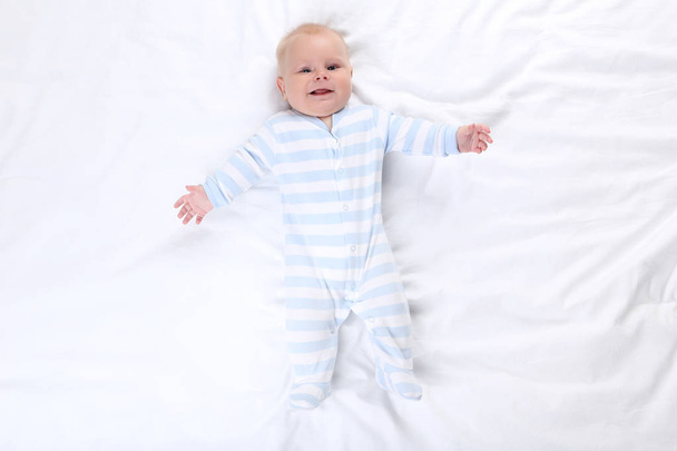 Baby boy lying on white bed - Fotoğraf, Görsel