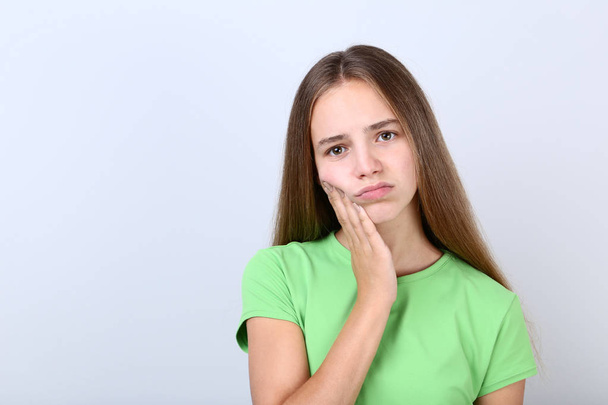 Young girl having toothache on grey background - Fotó, kép