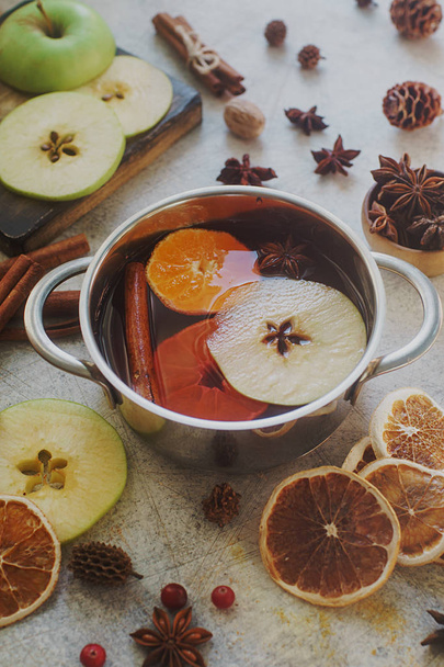 Homemade mulled wine with orange, apple and spices in aluminum casserole  - Foto, Bild