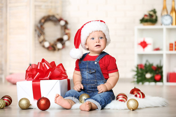 Baby boy with baubles and gift box sitting on floor at home - Φωτογραφία, εικόνα