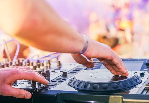 DJ mixování na beach party festivalu s lidé tančí v pozadí - Deejay hraje hudba směšovače zvuku venkovní - koncept letních akcí a klubu venkovní - Fotografie, Obrázek