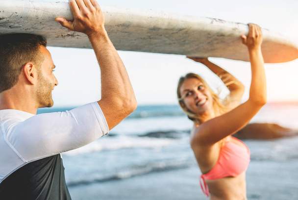 Szczęśliwa para kochających trzymając deskę surfingową i szukam siebie - znajomi, zabawa surfing podczas wakacji - ludzie relacji, podróży, sportowych koncepcja stylu życia - Zdjęcie, obraz