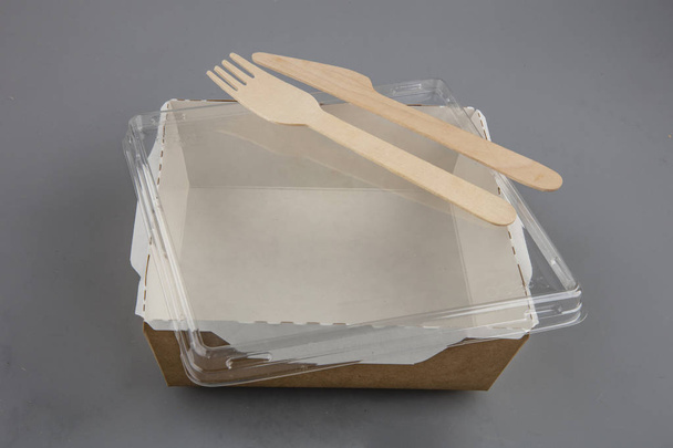 Lebensmittelkarton mit Holzgabel und Messer - Foto, Bild
