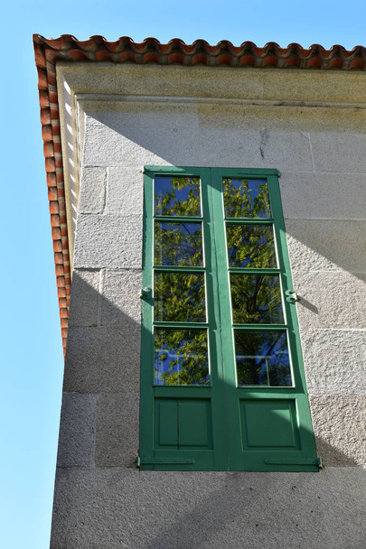Green window with tree reflection. Sunny day, blue sky. Pontevedra, Galicia, Spain. - Photo, Image