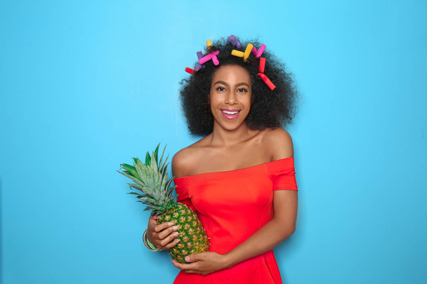 Beautiful African-American woman with pineapple on color background - Foto, imagen