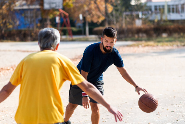 Père et fils jouant au basket dans le parc
 - Photo, image