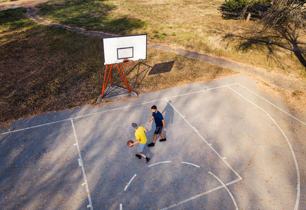 Père et fils jouant au basket dans le parc vue aérienne
 - Photo, image