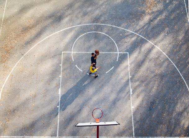 Πατέρας και γιος παίζοντας μπάσκετ με την εναέρια θέα στο πάρκο - Φωτογραφία, εικόνα