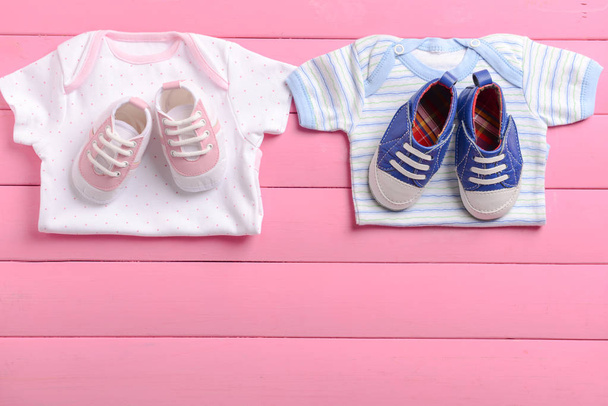 Vêtements et chaussures bébé sur fond de bois rose
 - Photo, image