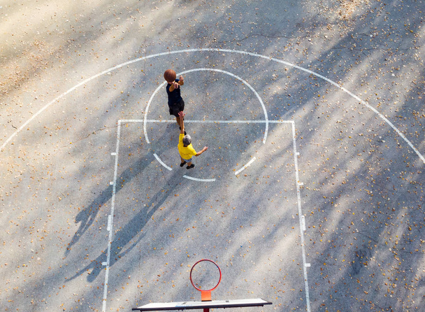Батько і син грають у баскетбол на аеродромі парку
 - Фото, зображення