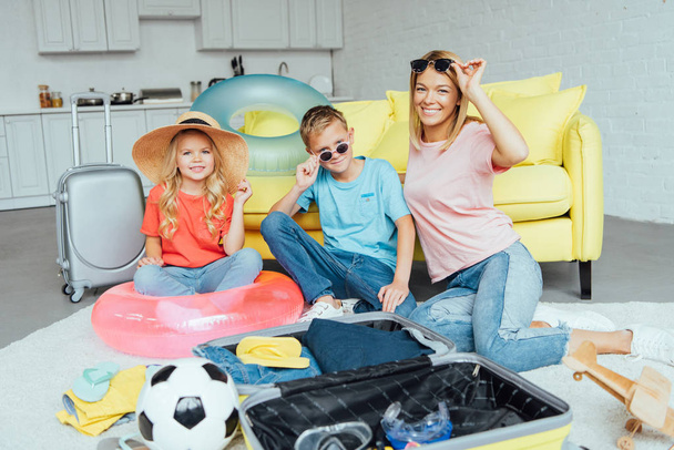boldog családi megpróbálja a strand-kiegészítőket és a csomagolás, vonatkozó nyaralás, utazási koncepció - Fotó, kép