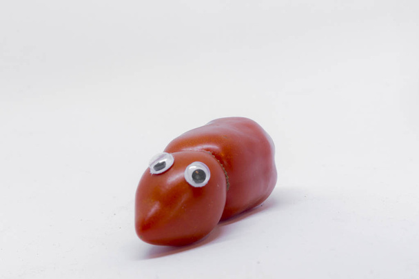 Tomaat met geplakte ogen op witte achtergrond - Foto, afbeelding