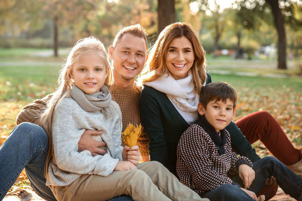 portret van een gelukkig gezin in het herfstpark - Foto, afbeelding