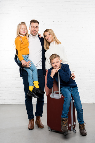ευτυχισμένη οικογένεια έτοιμο να πάει σε χειμερινές διακοπές με τις αποσκευές που βλέπουν την κάμερα σε άσπρο φόντο - Φωτογραφία, εικόνα