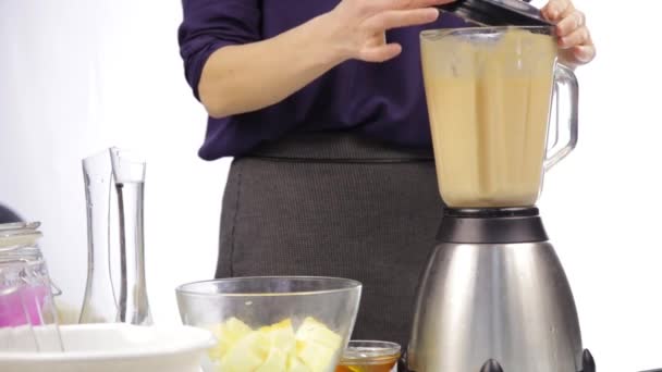 Woman making a fruit cocktail in a blender, smoothies preparation. - Felvétel, videó