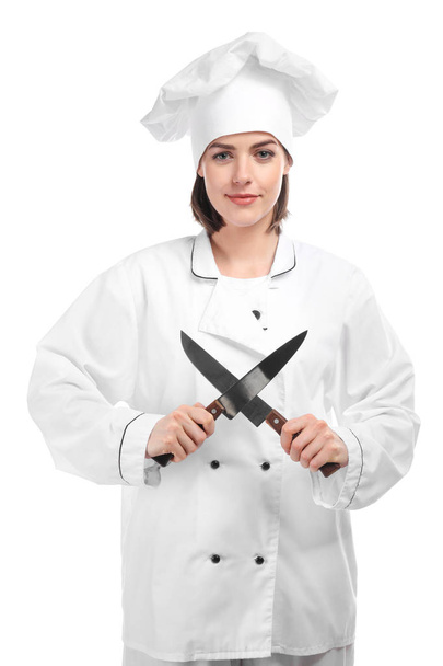 Νεαρή γυναίκα σεφ με μαχαίρια σε λευκό φόντο - Φωτογραφία, εικόνα