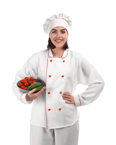 Νεαρή γυναίκα σεφ με λαχανικά σε λευκό φόντο - Φωτογραφία, εικόνα