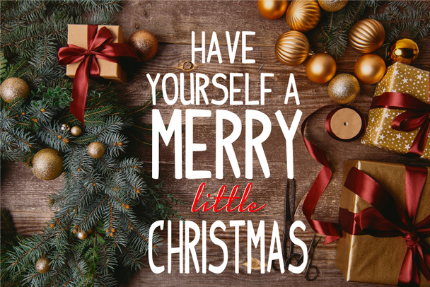 високий вид на різдвяні подарункові коробки, ялинковий вінок, стрічковий колір і ножиці на дерев'яному столі з "мати себе веселим маленьким різдвяним" натхненням
 - Фото, зображення