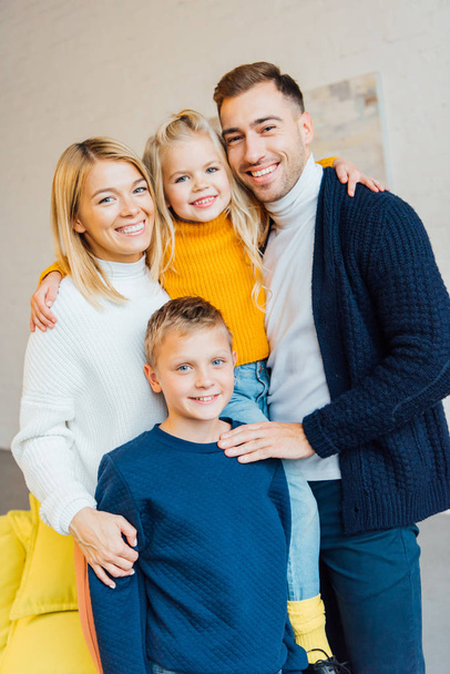 happy family in casual clothes hugging and looking at camera  - Fotoğraf, Görsel