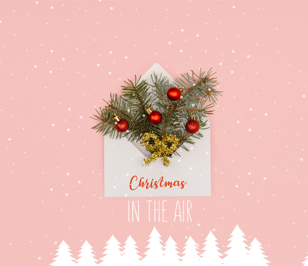 vista superior de sobre blanco con ramas de abeto y adornos de Navidad brillantes aislados en rosa con "Navidad en el aire" inspiración, nieve y árboles de Navidad ilustración
 - Foto, Imagen