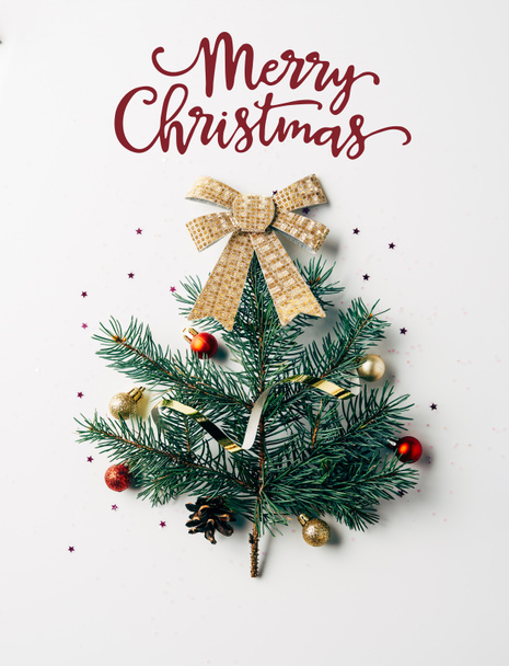 メリー クリスマス の文字と白い背景にリボン付きのお祝いクリスマス ツリーとして飾られた緑の松の枝の上から見る ロイヤリティフリー写真 画像素材