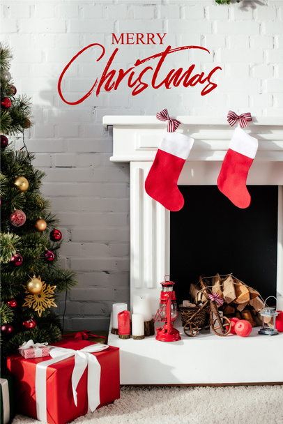 christmas tree with bubbles, gift boxes and fireplace with christmas stockings at home with "merry christmas" lettering - Photo, Image