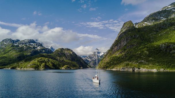 Yachting in de Troll Fjord op de achtergrond van besneeuwde bergen - Foto, afbeelding