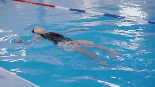 uimatunnit lapsille altaassa - kaunis vaalea tyttö ui vedessä
 - Materiaali, video