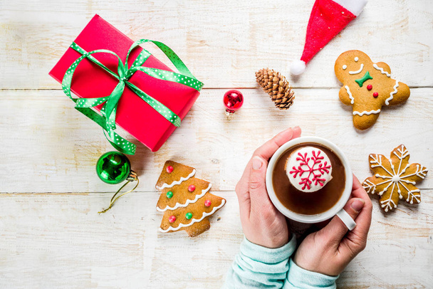 Christmas hot beverage ideas, girl drinking hot chocolate with marshmallow decorate with snowflake, hands in the picture, top view, copy space, with christmas decorations - Photo, Image