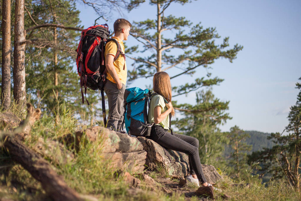 couple of tourists with backpacks hiking up a mountain - Fotó, kép