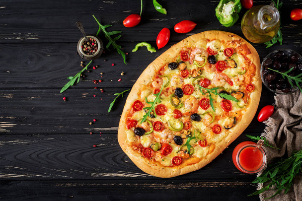leckere Meeresfrüchte-Garnelen und Muscheln-Pizza auf einem schwarzen Holztisch - Foto, Bild
