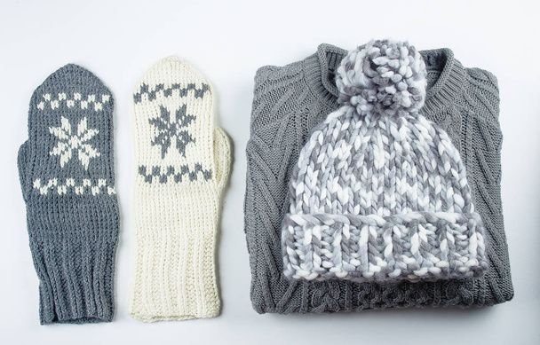 Kolekce z vlněné pletené svetr, rukavice, čepice na bílém pozadí tabulky - Fotografie, Obrázek
