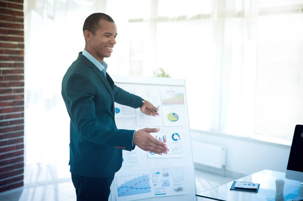 successful businessman pointing to a flip chart with the financial information. - Fotó, kép