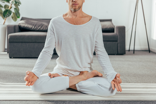 evde yoga mat üzerinde meditasyon spor giyim erkekte kadeh kırpılmış - Fotoğraf, Görsel