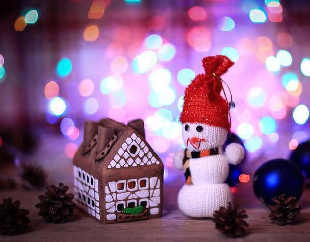 toy snowman and gingerbread house at the Christmas table - Fotografie, Obrázek