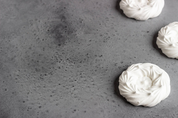 Mini Pavlova or meringue nests, selective focus. Grey concrete background. Copy space. - Fotoğraf, Görsel