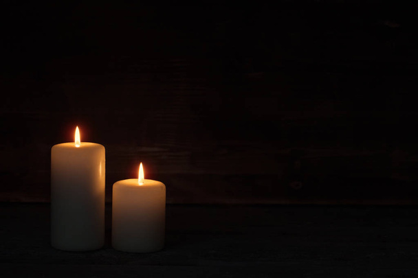 Burning candle on old dark wooden background - Fotoğraf, Görsel