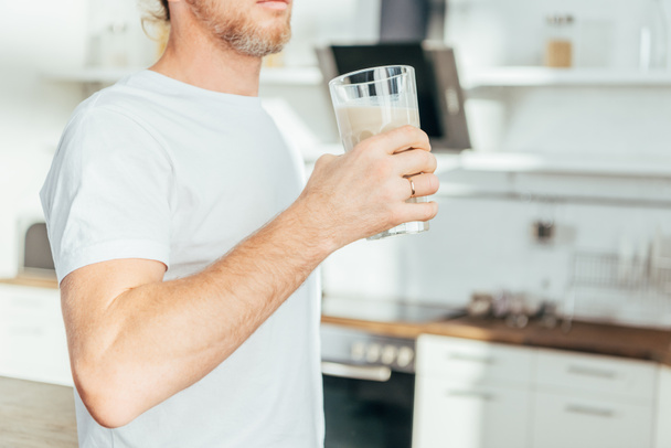 oříznutý snímek člověka doma drží sklo s proteinový koktejl - Fotografie, Obrázek