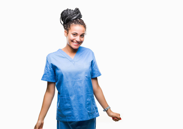 Jonge gevlochten haar Afrikaanse Amerikaans meisje professionele verpleegkundige over geïsoleerde achtergrond met een gelukkig en cool glimlach op het gezicht. Gelukkig persoon. - Foto, afbeelding
