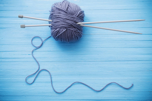 Knitting and knitting needles on a wooden surface - Fotoğraf, Görsel