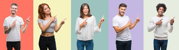 Composition of african american, hispanic and chinese group of people over vintage color background smiling and looking at the camera pointing with two hands and fingers to the side. - Photo, Image