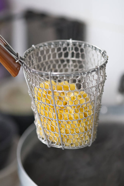 Chef-kok schroeien rauw ei noedels in traditionele staaldraad mesh noodle zeef - Foto, afbeelding
